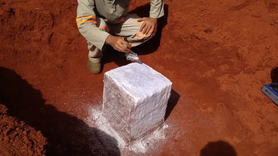 Bloco talhado recebendo as camadas de parafina que preservam a umidade natural do solo.