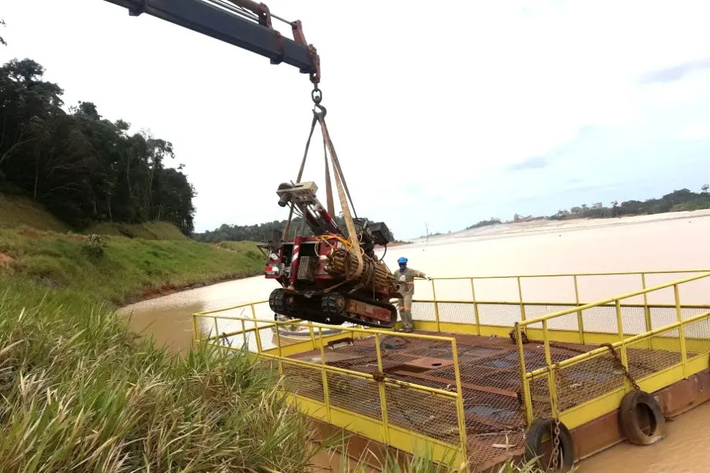 Equipamento de sondagem montado sobre plataforma flutuante em lâmina d'água.